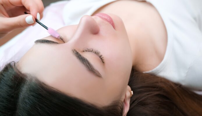 Photo young woman doing eyelash lamination eyelash extensions M curl classic lashes procedure in a beauty salon