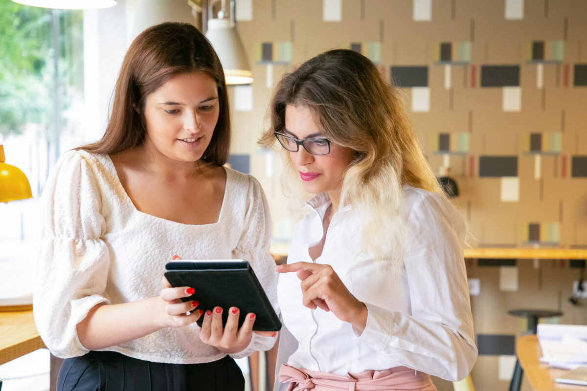 young-professional-women-standing-together-watching-design-screen-clients-lavislash-lash-extensions