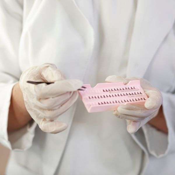 front-view-specialist-holding-eyelashes-tweezers-lash-studio-lash-artist